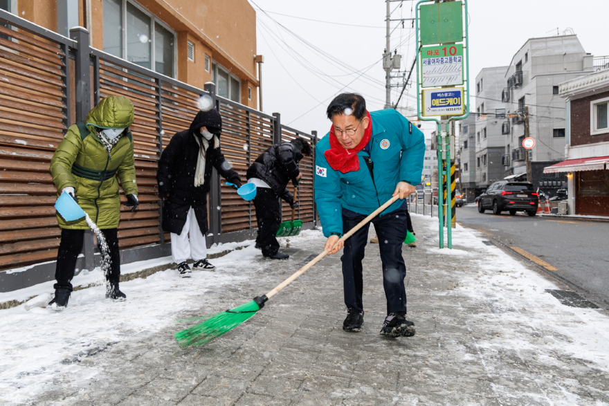 지난해 박강수 마포구청장이 학생 안전을 위해 통학로에서 제설작업을 하고 있다.(1).jpg
