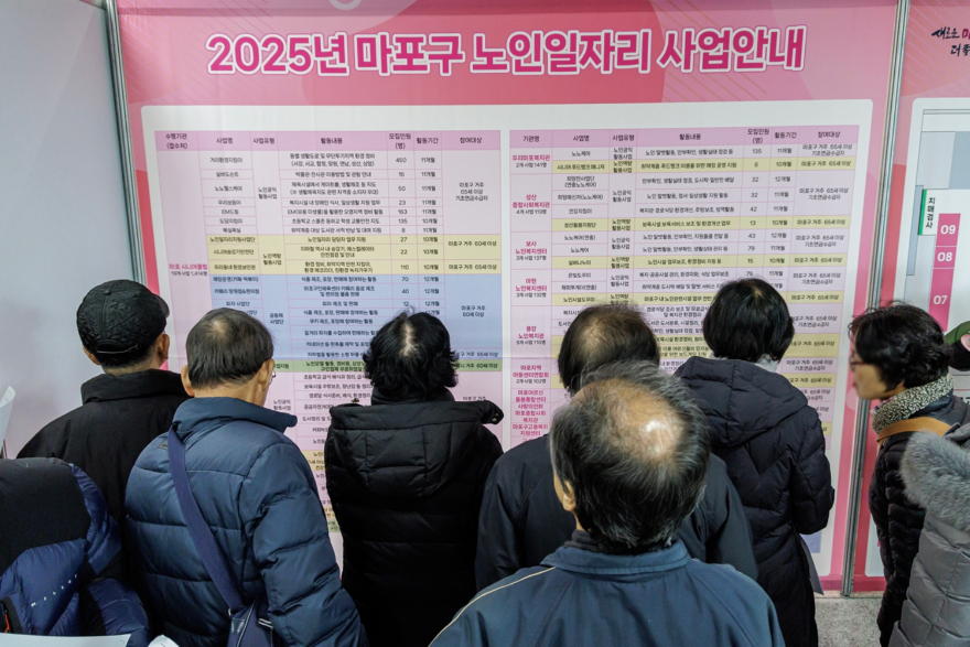 ‘2025 마포구 노인일자리 박람회’를 찾은 어르신들이 일자리 사업 안내 게시판을 살펴보고 있다..jpg