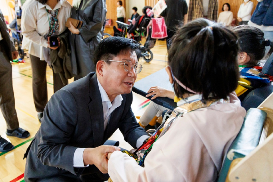 몸을 낮추고 한국우진학교 학생들과 인사를 하는 박강수 마포구청장.jpg